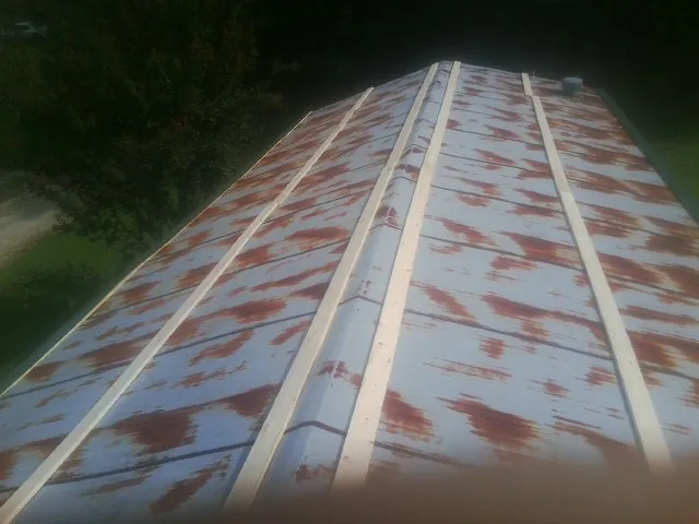 Rusted metal roof panels with new wood purlins before replacement — Storm Damage Roof Repair in North Springfield by Roofing Brothers