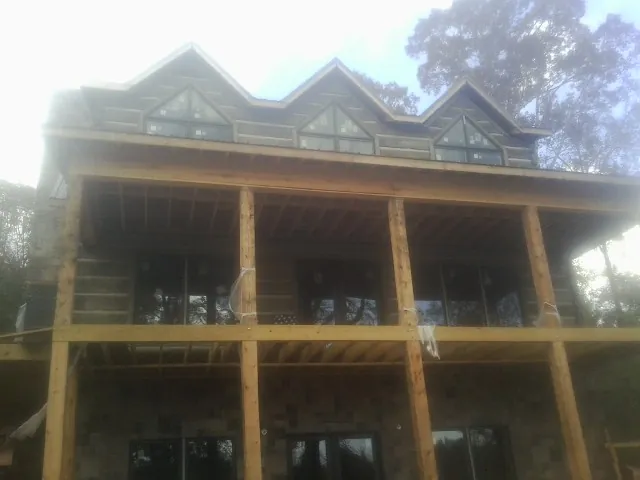 Dormers and porch framing on a large log home under construction — Roof Coating work by our crew in North Springfield
