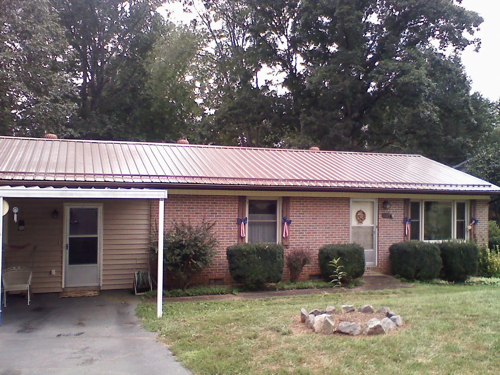 Bronze metal roof and carport on a brick ranch home — Roof Repair work by our crew in North Springfield